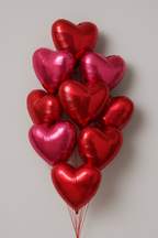 Bunch of red and pink heart-shaped balloons on a light gray background