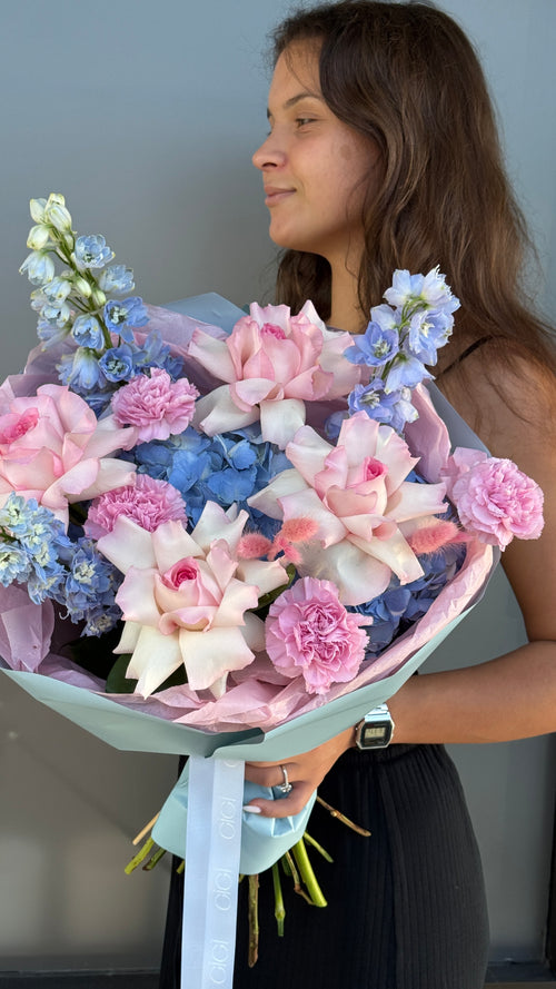 Handcrafted garden rose and hydrangea bouquet in soft blue and pink tones