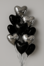 Bouquet of black and silver heart-shaped balloons on a plain background