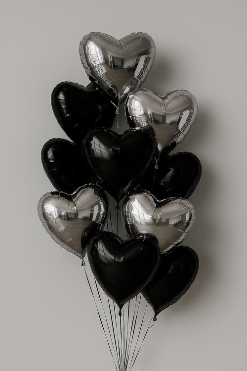 Bouquet of black and silver heart-shaped balloons on a plain background