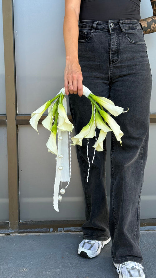 Person holding white flowers against a neutral background