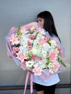 Person holding a large bouquet of flowers with a plain background