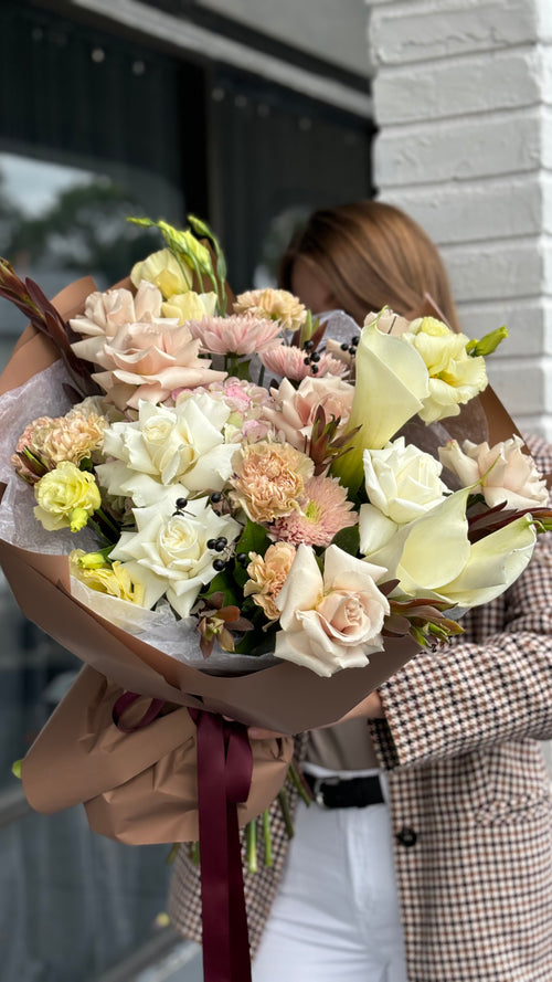 Bouquet of flowers held by a person wearing a checkered coat.