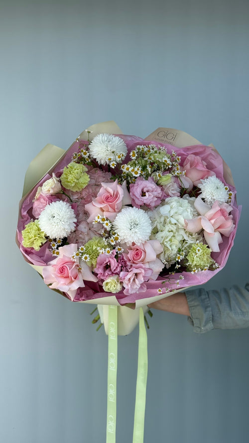 Bouquet of flowers with pink, white, and green colors against a plain background