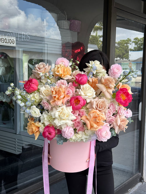 Pink basket with colorful flowers and ribbons