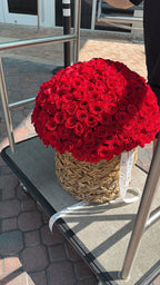 A basket of 200 red roses displayed outdoors, likely as part of a romantic flower arrangement.