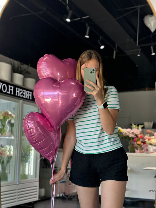 Three heat shaped pink balloons