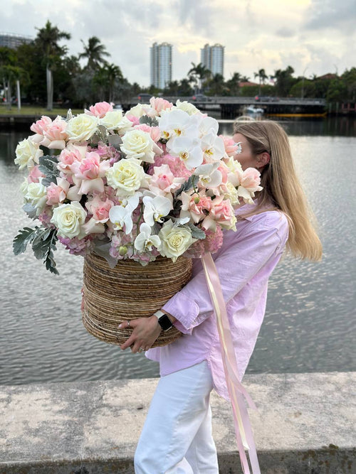 Pink and creme colored roses flowers in a wide basket.