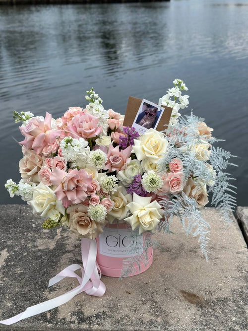 Multi-colored flowers in a basket with ribbons