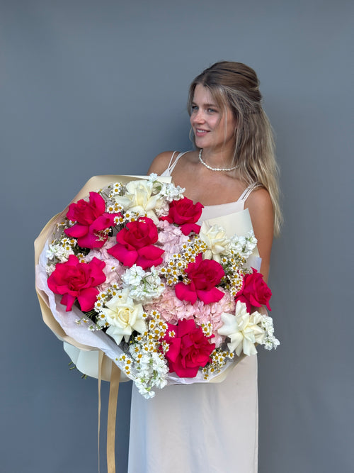 Romantic bouquet featuring hot pink roses, chamomile and white garden roses